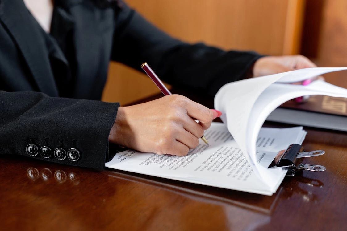 Person writing on legal documents
