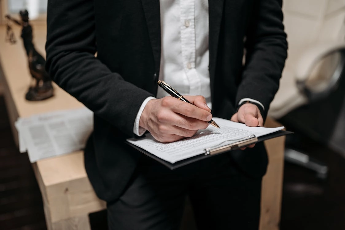 Man signing documents in formal attire