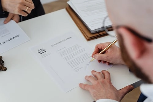 Signing divorce papers on a table.