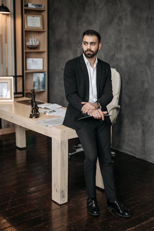Man in suit standing by desk